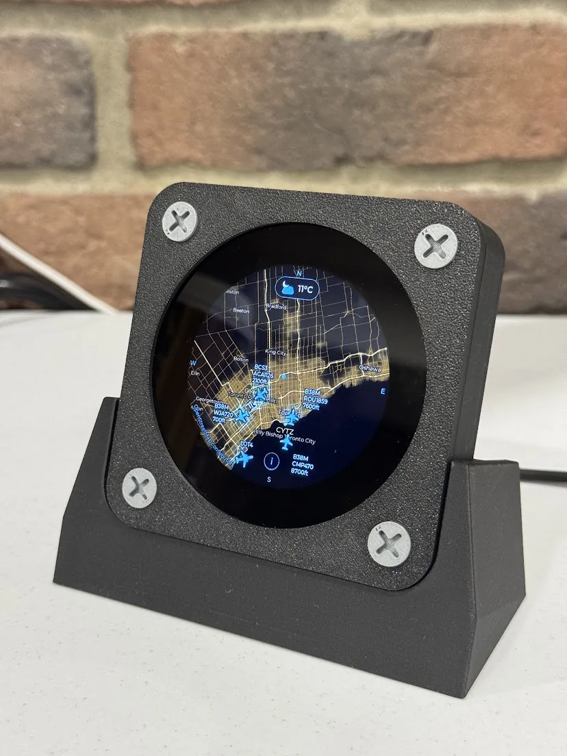 Flyover on a white desk against a brick wall, showing a map of Toronto with labelled aircraft and 11 degrees on top.
